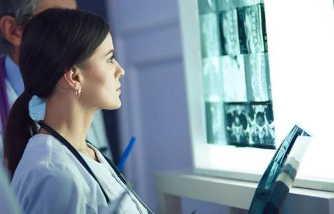 Group of doctors examining x-rays in a clinic, thinking of a diagnosis Stock Photos