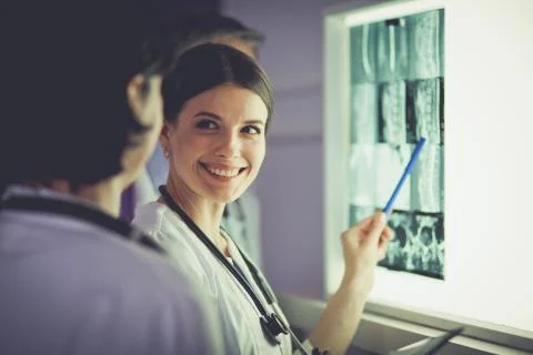 Group of doctors examining x-rays in a clinic, thinking of a diagnosis Stock Photos