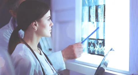 Group of doctors examining x-rays in a clinic, thinking of a diagnosis Stock Photos