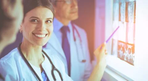 Group of doctors examining x-rays in a clinic, thinking of a diagnosis Stock Photos