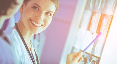 Group of doctors examining x-rays in a clinic, thinking of a diagnosis Stock Photos