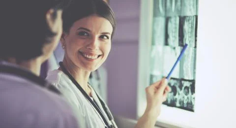 Group of doctors examining x-rays in a clinic, thinking of a diagnosis Stock Photos