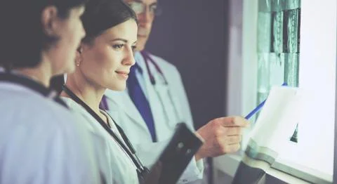 Group of doctors examining x-rays in a clinic, thinking of a diagnosis Stock Photos