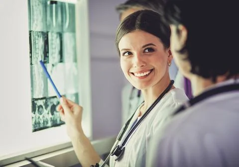 Group of doctors examining x-rays in a clinic, thinking of a diagnosis Stock Photos