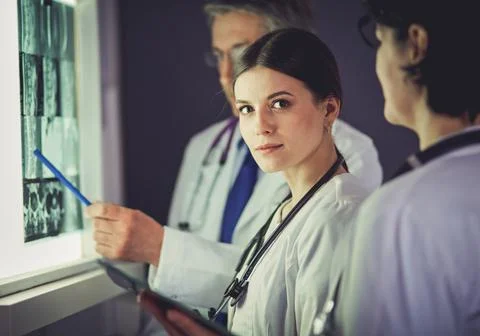 Group of doctors examining x-rays in a clinic, thinking of a diagnosis Stock-Fotos
