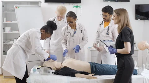 Group of doctors at a first aid course attending to mannequin in a clinic 動画素材 270172365