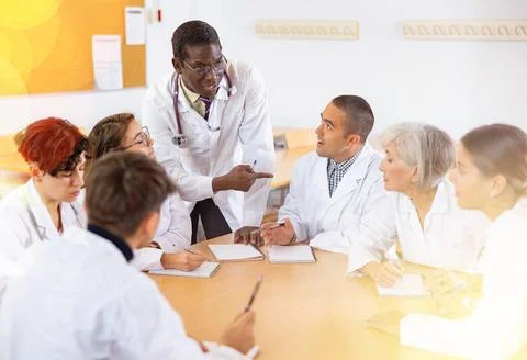 Group of doctors having discussion in classroom of medical university Stock Photos