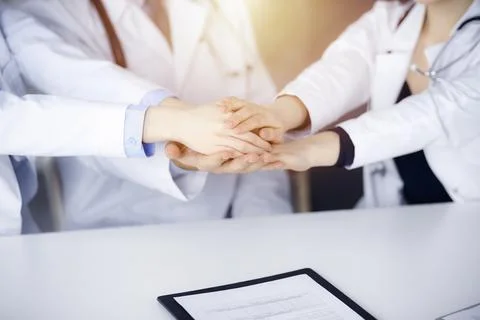 Group of doctors joining hands as a circle and ready to help patients while Фото