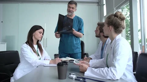 Group of doctors looking at X-ray on medical conference Stock Footage 135186043
