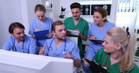 Group of Doctors Optimistic Talking in Hospital Room Planning Medical Activity Stock Footage 87977302