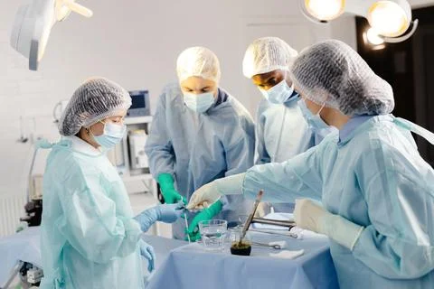 Group of doctors performing surgery in operating room Stock Photos