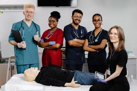 Group of doctors standing at the bed with mannequin at first aid training c.. Stock Photos