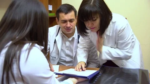 A group of doctors talking. Two women and a man. Look in the folder with the Stock Footage 74250916
