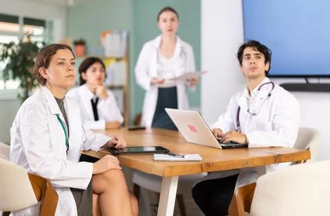 Group of doctors watching presentation at table Stock Photos