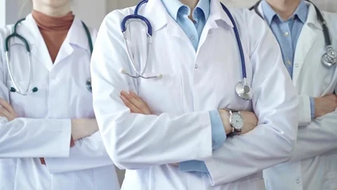 Group of doctors wearing white coats and stethoscopes standing with arms crossed Stock Footage 279750484