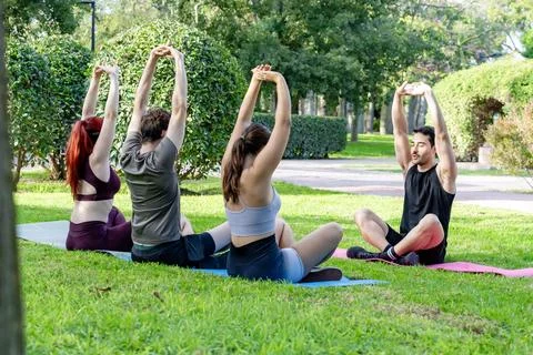 Group doing yoga with instructor in park Stock Photos