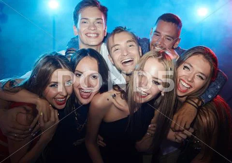 Group of ecstatic friends laughing at party in nightclub Stock Photos