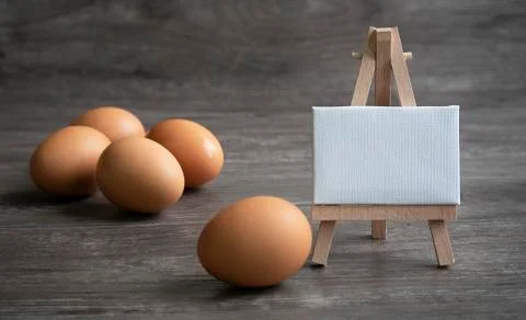 Group of eggs with mini white white board on woodden floor. Stock Photos