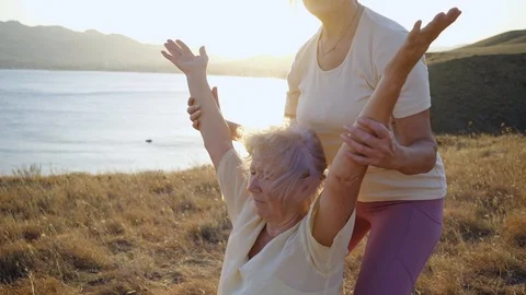 Group of elderly people doing yoga at sunset 스톡 동영상 123076925