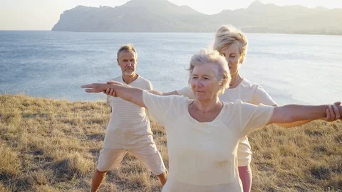 Group of elderly people doing yoga at sunset Video stock 123076985