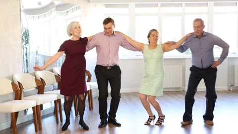Group of elderly people with middle-aged man perform Irish folk dance Stock Footage 272404767