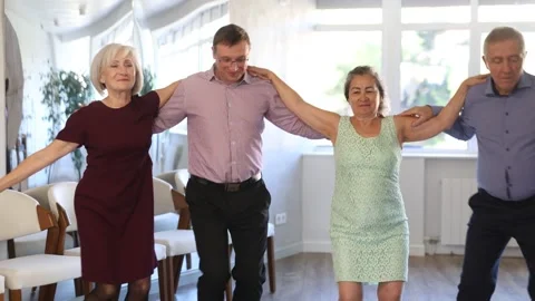 Group of elderly people with middle-aged man perform Irish folk dance during New Stock Footage 276947190