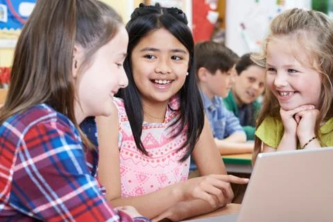 Group Of Elementary School Children Working Together In Computer Class Stock Photos