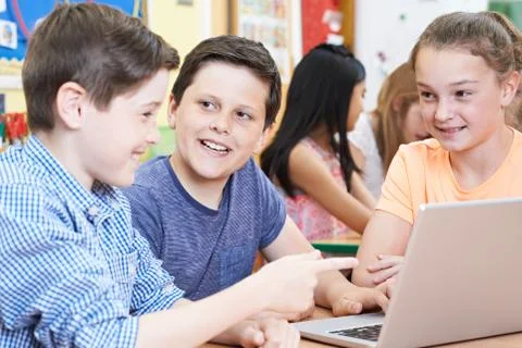 Group Of Elementary School Children Working Together In Computer Class Stock Photos