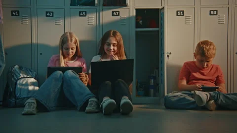 Group of Elementary School Students Sitting on Floor by Metal Lockers During Stock Footage 342035992