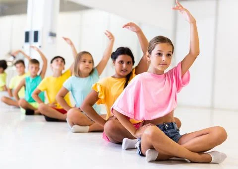 Group of emotional children doing yoga in dance studio Stock Photos