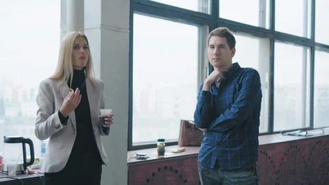 A group of employees stands and communicates in the loft office during the lunch Stock Footage 107390737