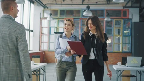 A group of employees walking around the office, lively discussing a business Stock Footage 107527630