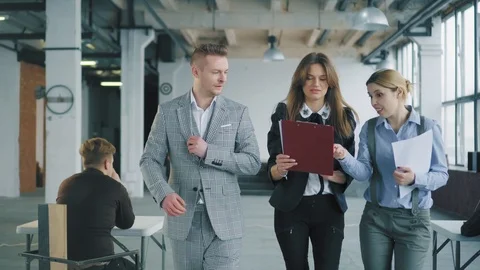 A group of employees walking around the office, lively discussing a business Stock Footage 108394082