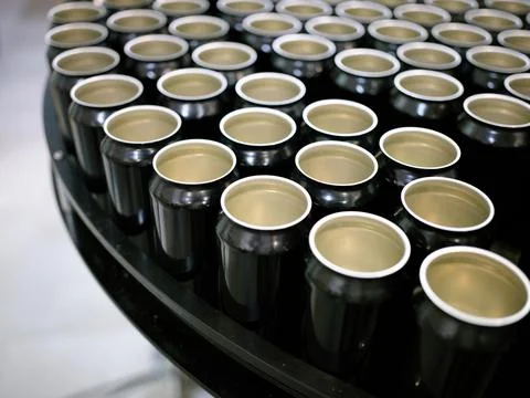 Group of empty beer cans on a platform of a brewery packaging plant Stock Photos