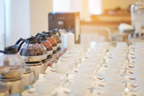 Group of empty Many rows of white ceramic coffee or tea cups and spoons on gl Stock Photos