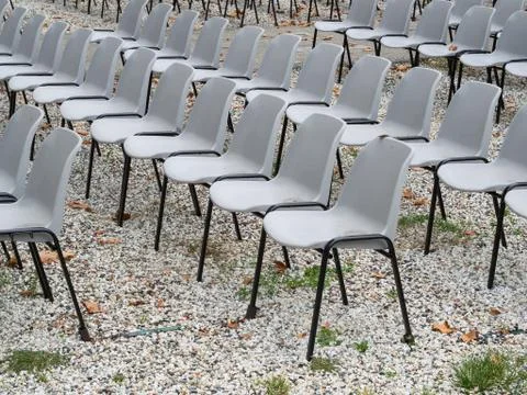 Group of empty plastic chairs arranged in row for events Foto stock