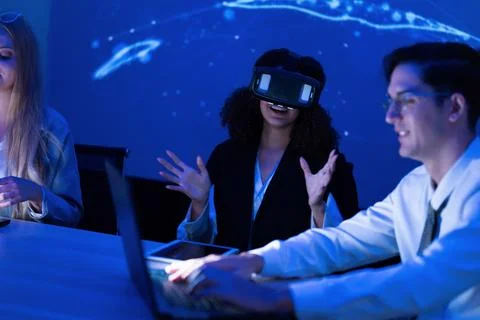 Group engages in virtual reality experiences at tech workshop in a dimly li.. Stock Photos