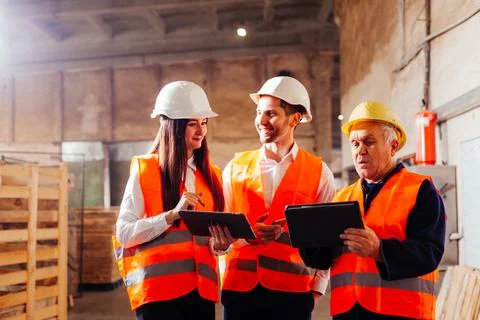 Group of engineers and workers discuss production plans Stock Photos