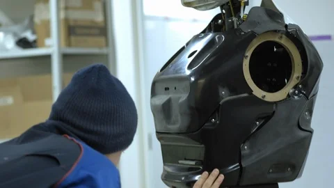 A group of engineers creates a modern robot or android. Check and repair broken Stock Footage 101372416