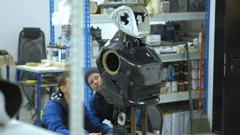 A group of engineers creates a modern robot or android. Check and repair broken Stock Footage 101373779