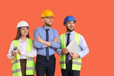Group of engineers with laptop on orange background Stock Photos