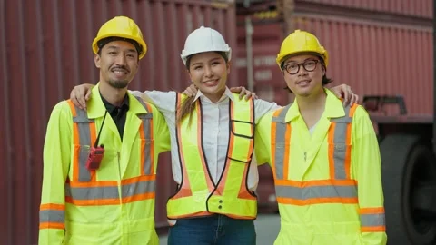 Group of engineers in safety uniform, with arm around shoulder looking at camera Stock-Footage 261938510