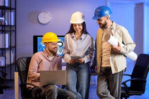Group of engineers working with gadgets in office at night Stock Photos