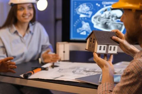 Group of engineers working with house model in office at night, closeup Stock Photos