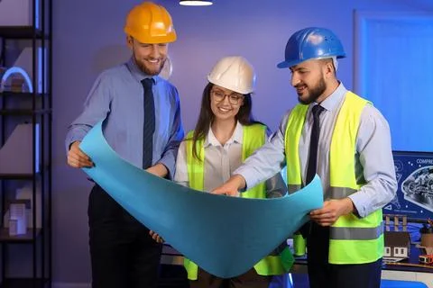 Group of engineers working with house plan in office at night Stock Photos
