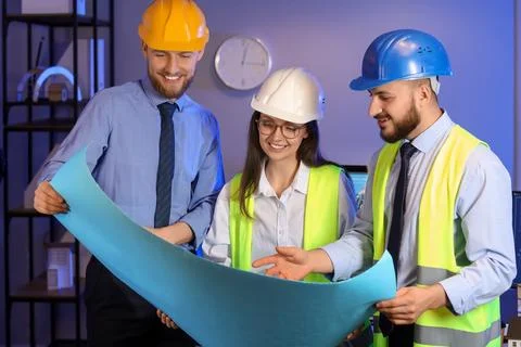 Group of engineers working with house plan in office at night Stock Photos