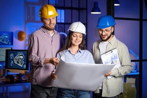 Group of engineers working with house plan in office at night Stock Photos