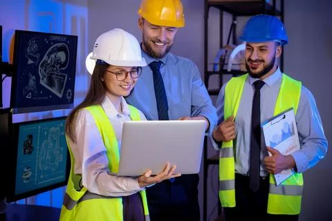 Group of engineers working with laptop in office at night Stock Photos