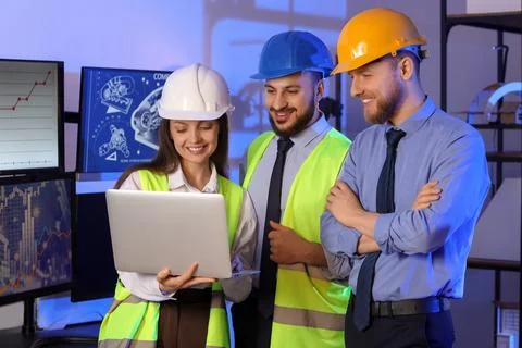 Group of engineers working with laptop in office at night Stock Photos