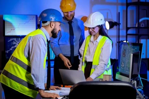 Group of engineers working with laptop in office at night Stock Photos